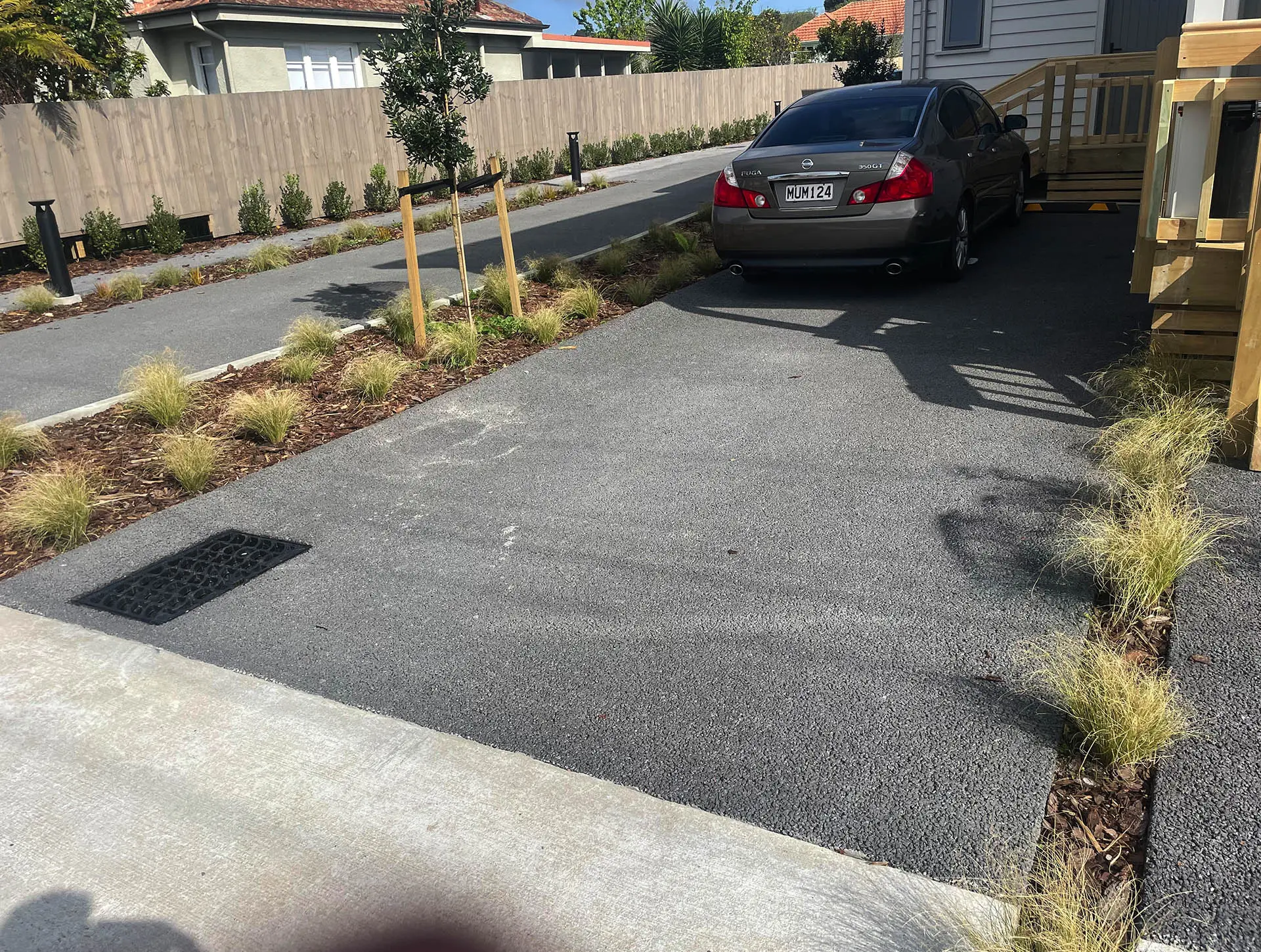 Permeable-Concrete-New-Zealand-contemporary-home-pervious-paving Permeable concrete driveway in front of modern residential buildings.